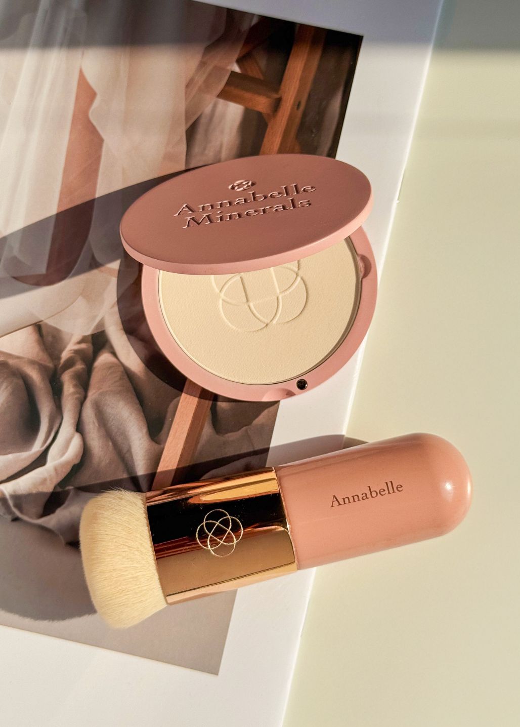 Prasowany podkład mineralny Annabelle Minerals i pędzel short top do makijażu na stylowym tle