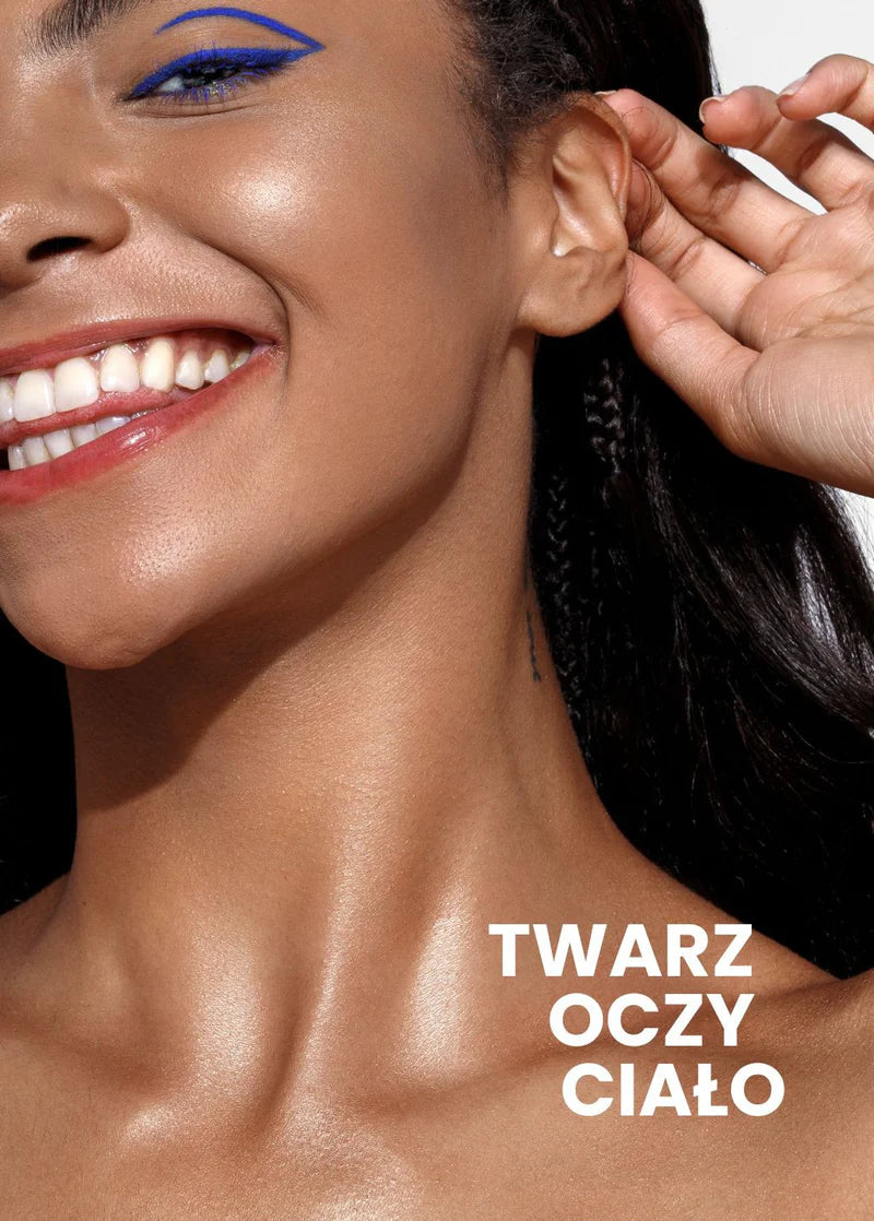 Uśmiechnięta kobieta z promienną cerą i wyrazistym niebieskim eyelinerem na powiece