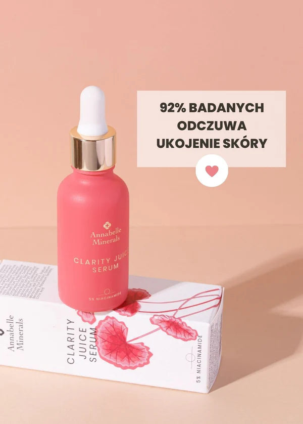 Różowa buteleczka serum Clarity Juice Annabelle Minerals z pipetą na białym pudełku, wskazująca na łagodzący działanie produktu do pielęgnacji skóry