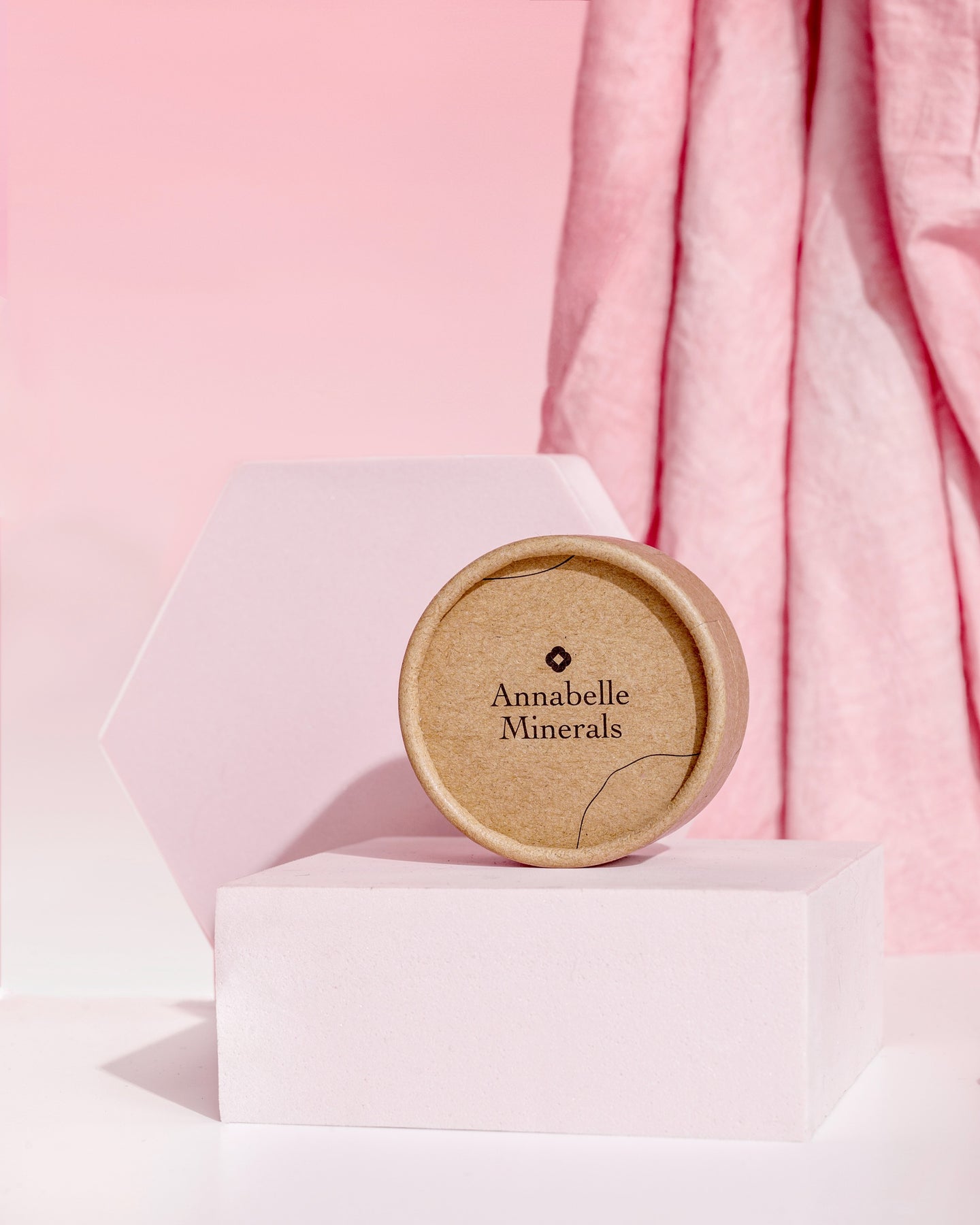 Produkt Annabelle Minerals na różowych, stylizowanych postamentach z delikatnym tłem