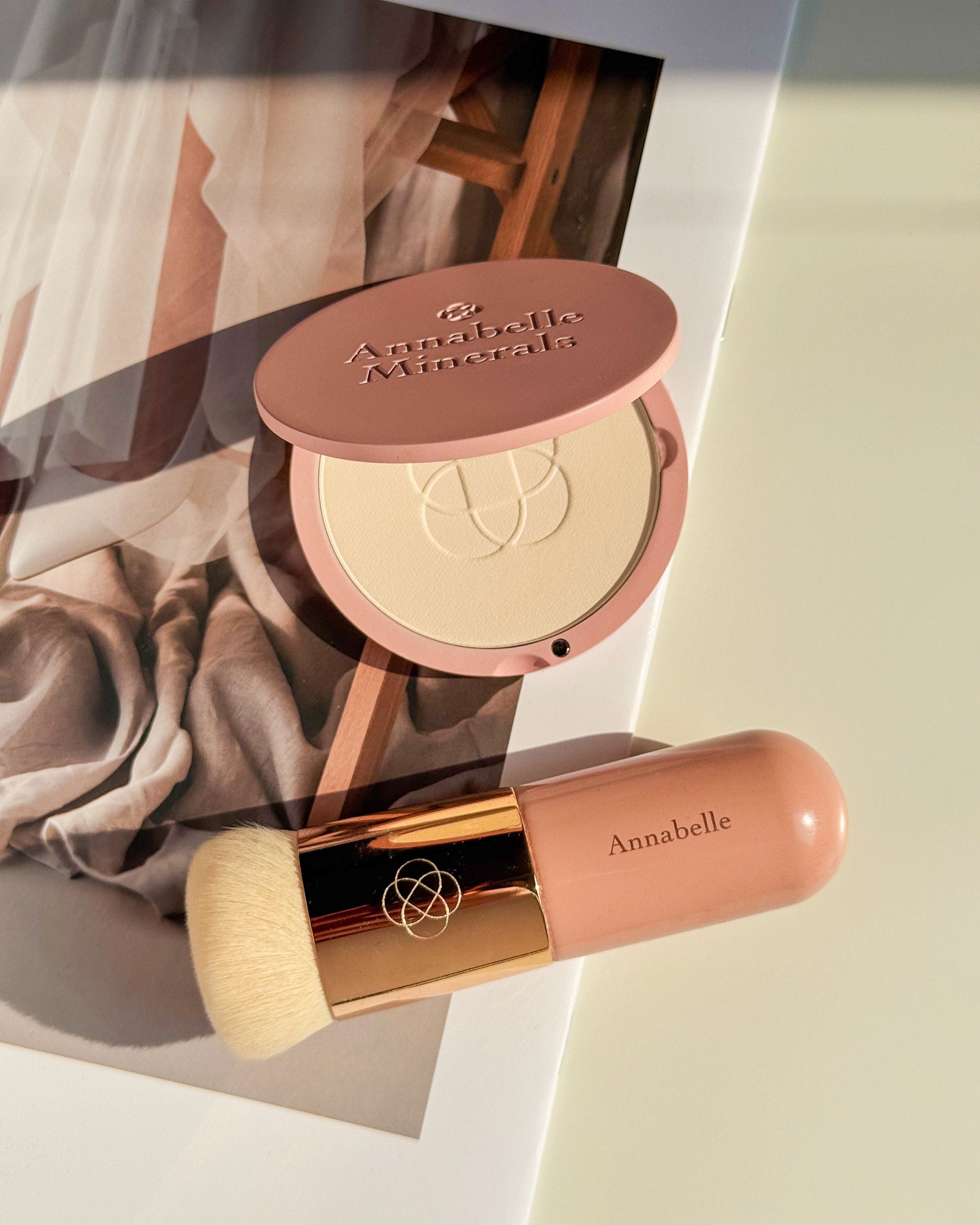 Kompaktowy podkład Annabelle Minerals z pędzelkiem short top na delikatnym tle
