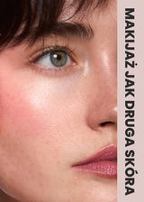 Rumieniec wykonany kremowym różem Soft Petal Annabelle Minerals na twarzy uśmiechniętej osoby z promienną skórą