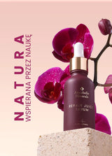 Butelka serum Repair Juice Annabelle Minerals do pielęgnacji skóry obok kwiatu orchidei na teksturowanej powierzchni