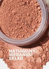 Pojemnik z naturalnym różem rozświetlającym Annabelle Minerals oraz rozsypane wokół drobinki proszku