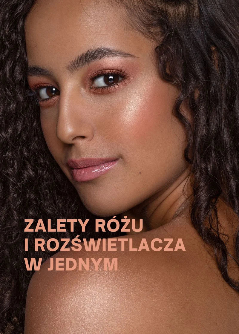 Portret osoby z kręconymi włosami, podkreślającej makijaż różem rozświetlającym Annabelle Minerals