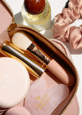 Różowa kosmetyczka z akcesoriami do makijażu Annabelle Minerals, w tym pędzel i mała buteleczka perfum
